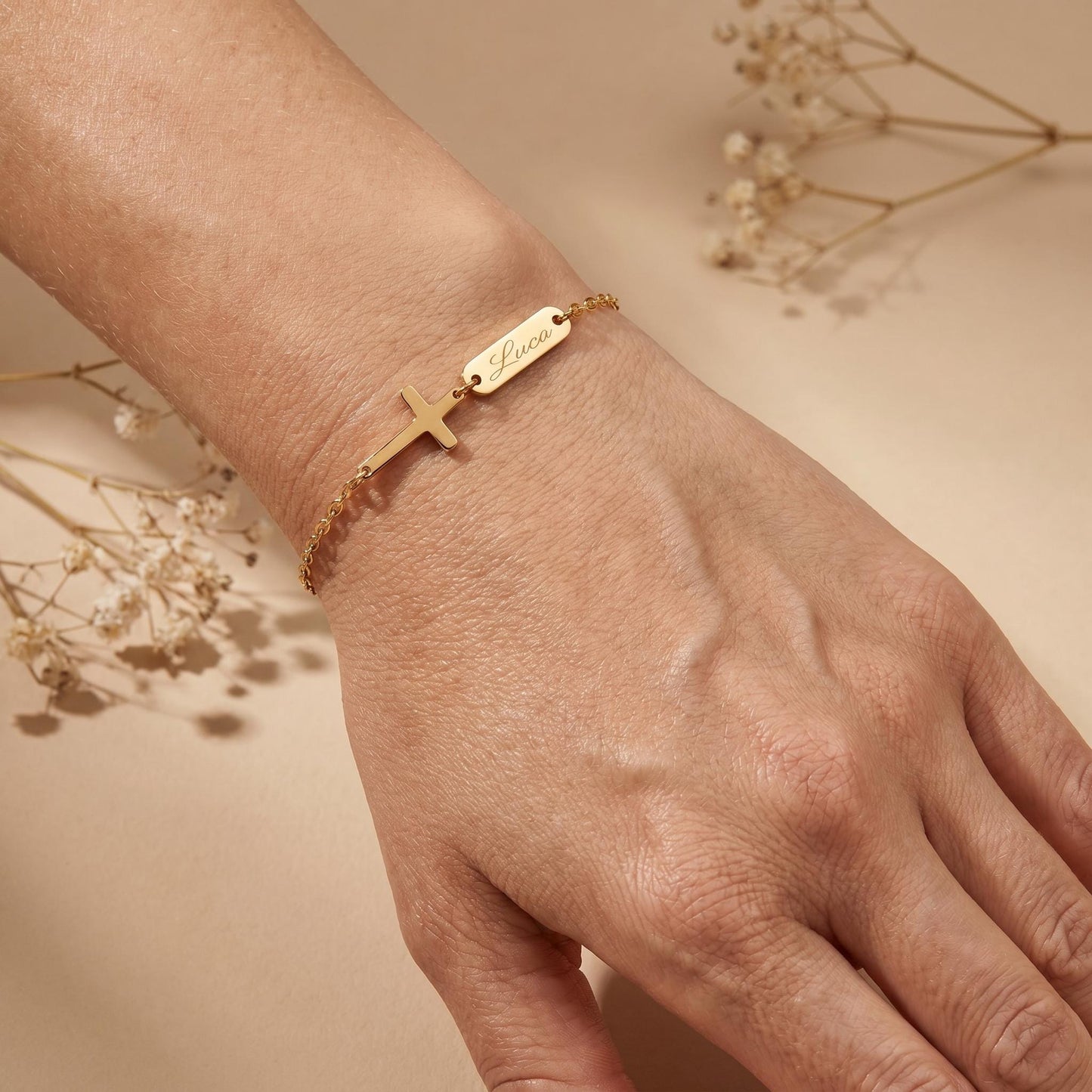 Personalisiertes Tauf-Armband mit graviertem Kreuz und Namen in Gold, am Handgelenk getragen – inaklam