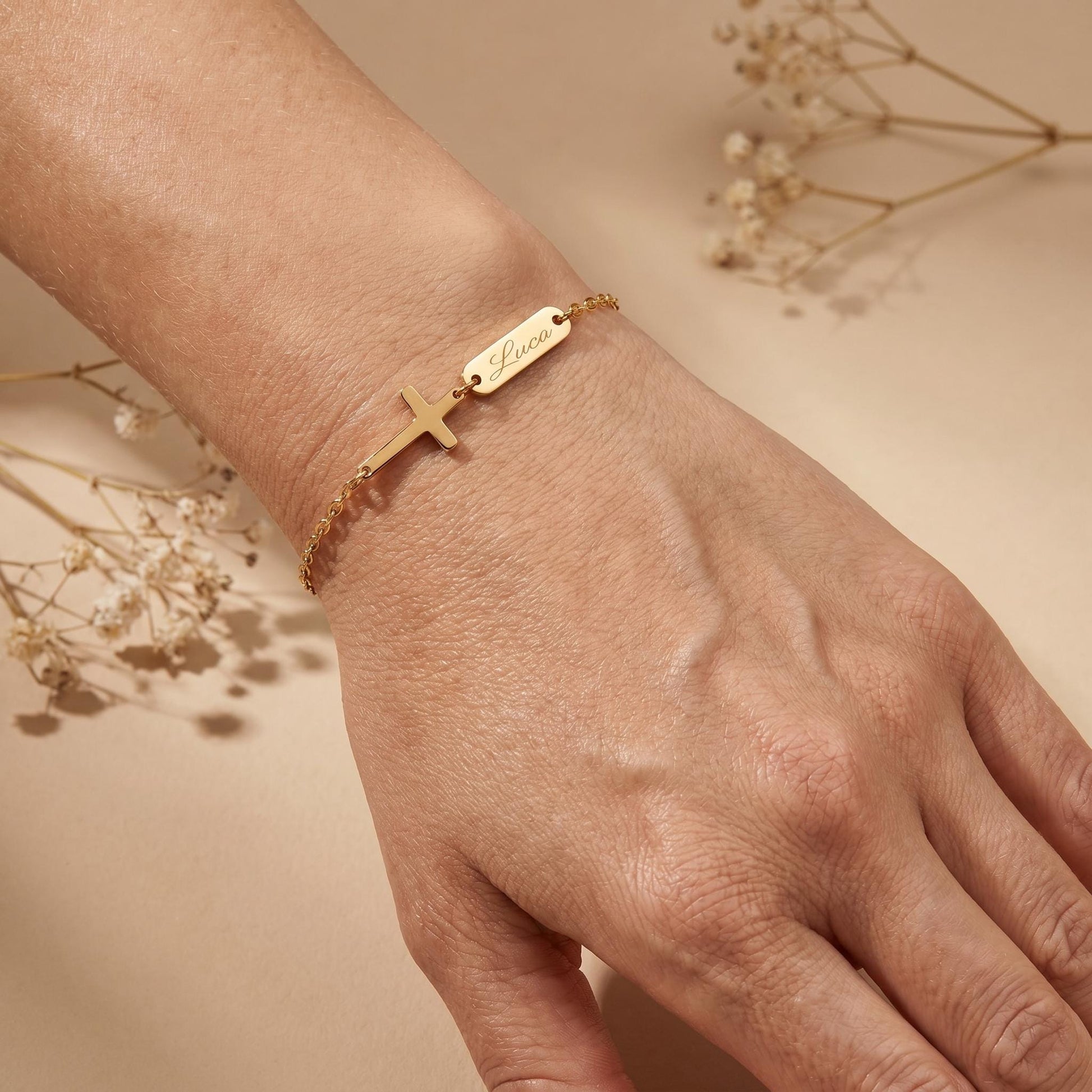 Personalisiertes Tauf-Armband mit graviertem Kreuz und Namen in Gold, am Handgelenk getragen – inaklam